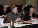 ARRL New England Division Director Tom Frenaye, K1KI, discusses a motion at the meeting, while Northwestern Division Director Jim Fenstermaker, K9JF, looks through his notes. Northwestern Division Vice Director Grant Hopper, KB7WSD, and Roanoke Division Vice Director Jim Boehner, N2ZZ, are seated behind Frenaye and Fenstermaker. [Steve Ford, WB8IMY, Photo]